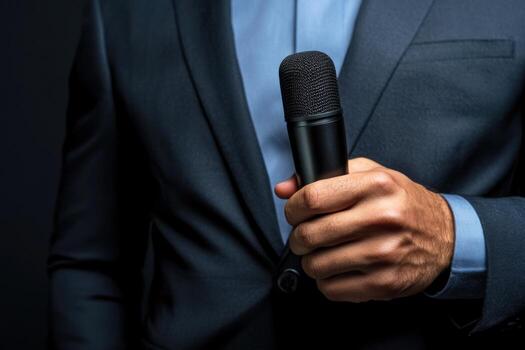 Professional speaker holding a microphone against a dark background before an important presentation event photo