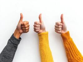 Three hands giving thumbs up against a plain background show approval and positive feedback in a casual setting photo