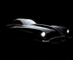 Classic car illuminated in dark setting showcasing vintage design and craftsmanship details photo