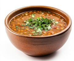 Delicious lentil soup garnished with fresh herbs in a rustic bowl photo