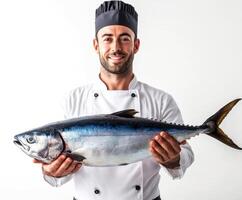 Professional chef holding a large fresh tuna fish in a bright kitchen setting photo
