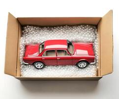 Model car carefully packed in a box filled with protective material for shipping or storage photo