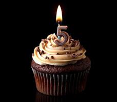Celebrate a special birthday with a delicious cupcake featuring a lit candle for turning five years old photo