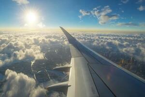 Captivating view from airplane wing soaring above clouds at sunset over city landscape photo