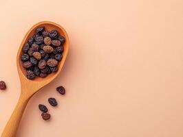 wooden scoop filled with assorted raisins on neutral background, showcasing their rich colors and textures, perfect for culinary use or healthy snacking photo