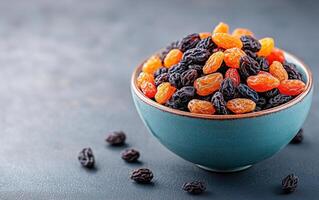 Dried mixed raisins in ceramic bowl, showcasing vibrant colors and textures. Perfect for healthy snacking or baking photo