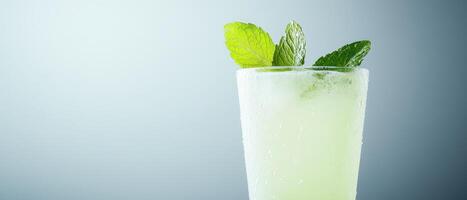 Refreshing mojito glass with condensation and mint leaves on top photo