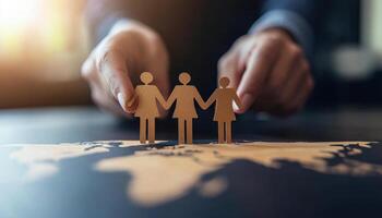 Hands placing cutout figures on world map, symbolizing unity and connection. This creative representation highlights importance of collaboration and teamwork photo