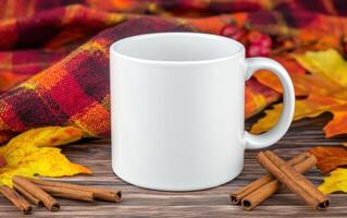 blank white mug surrounded by autumn leaves and cinnamon sticks, perfect for seasonal beverages. cozy setting evokes warmth and comfort photo