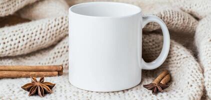 blank white mug on cozy knitted blanket with cinnamon sticks and star anise, creating warm and inviting atmosphere perfect for enjoying hot beverage photo