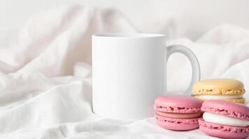 close up of blank white mug beside colorful macarons on soft fabric background, creating cozy and inviting atmosphere. Perfect for showcasing beverages or desserts photo
