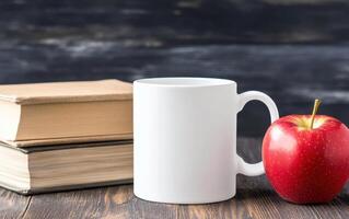 blank white mug sits beside red apple and stacked books, creating cozy study atmosphere. Perfect for coffee lovers and book enthusiasts photo