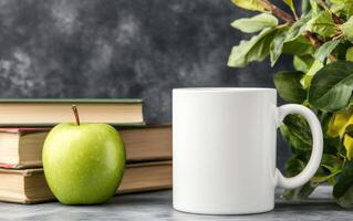 blank white mug sits beside green apple and stacked books, surrounded by leafy greenery, creating serene and inviting atmosphere for study or relaxation photo