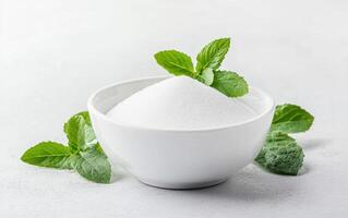Zero calorie sweetener in white bowl with fresh mint leaves, creating refreshing and healthy vibe. Perfect for sugar alternatives and healthy cooking photo