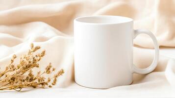 blank white mug sits elegantly on soft, neutral fabric, accompanied by dried flowers, creating serene and minimalist aesthetic photo
