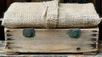 A charming wooden box with rustic charm is topped with a natural burlap fabric, perfect for storage photo