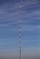 Symmetric view of red and white radio tower photo