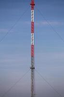 Symmetric view of red and white radio tower. photo