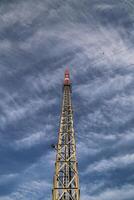 Red and white radio tower in an unusual angle photo