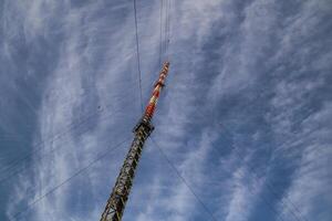 Red and white radio tower in unusual angle photo