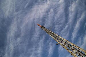 A red and white radio tower in unusual angle photo