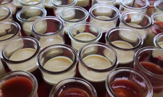 Pudding dessert with a fruit sauce in glasses. photo