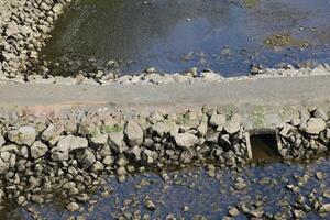 A rock dam with sewer for the water on both sides. photo