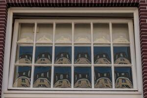 A window with a reflection of a building photo