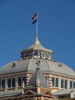 A building with a clock tower and a dutch flag photo