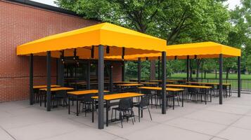 Outdoor Patio Restaurant with Yellow Canopies Black Tables and Chairs Park Setting photo