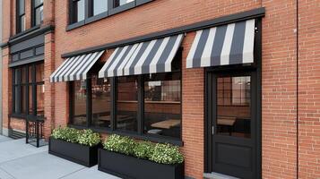 Modern Restaurant Exterior with Black Striped Awnings Brick Facade and Planters photo