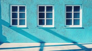 Turquoise wall glimmers under sunlight, casting gentle shadows from overhead structures photo