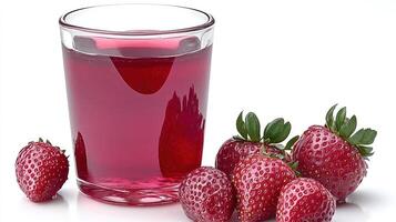 A colorful glass filled with berry drink is placed next to fresh strawberries on a white surface photo