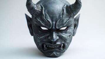 A devil mask with sharp features and bold horns showcases fierce artistry photo