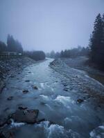 River arve flowing through misty chamonix valley in autumn photo