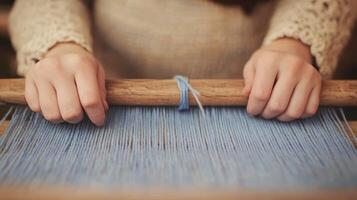 Hands Weaving Blue Threads on a Loom in Traditional Textile Crafting Scene photo