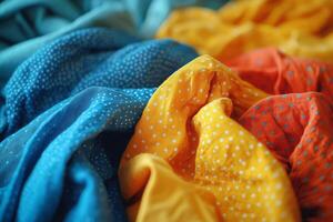 Vibrant textiles featuring blue, orange, yellow, and turquoise colors displayed in an artistic arrangement on a flat surface photo