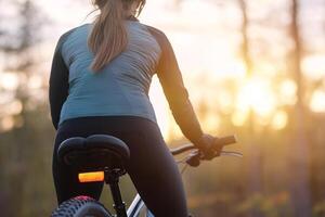 A cyclist enjoys a tranquil sunset ride through a forest trail, embracing the calm evening air and nature's beauty photo