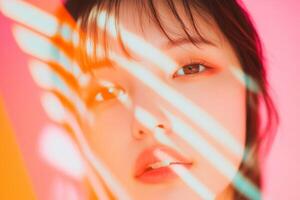 A close-up portrait of a young woman with soft features, colorful lighting, and striking shadows against a vibrant background in an artistic setting photo