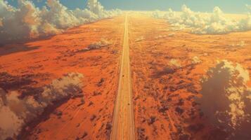 Vast desert road stretching into horizon with blue sky and clouds photo