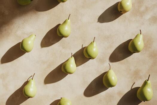 Multiple fresh pears arranged on a light surface creating a geometric pattern photo