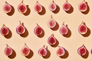Sliced figs arranged in symmetrical pattern on a beige background for food concept photo