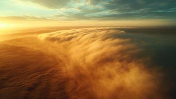 Stunning aerial view of desert sandstorm at sunrise with golden dunes photo