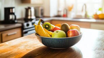 Fruit bowl with apples bananas and kiwi in sunlit kitchen setting photo