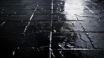 Shiny wet cobblestone pavement at night with mirrored water reflections photo