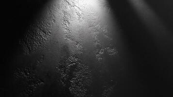 Textured black concrete surface illuminated by spotlight with subtle shadows photo