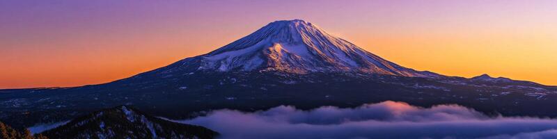 Majestic mountain peak during sunrise with snow-capped summit and vibrant sky photo