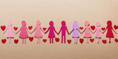 Paper cutout figures holding hands with hearts symbolizing love and unity photo