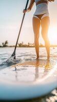 stand-up paddleboarder paddling through gentle waves at the beach photo