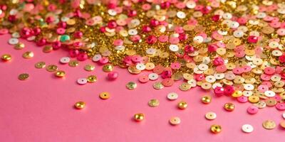 A Vibrant Display of Colorful Confetti and Sequins Set Against a Pink Background photo